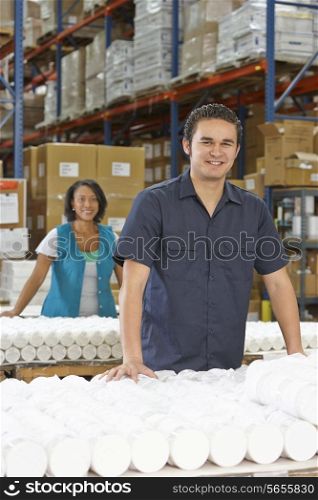 Factory Worker Checking Goods On Production Line