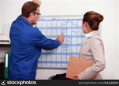 factory worker showing the schedule to the manager