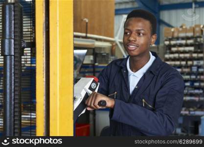 Factory Worker Using Powered Fork Lift To Load Goods