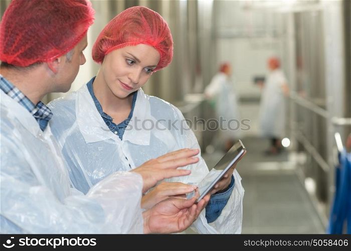 factory workers in workshop using digital tablet
