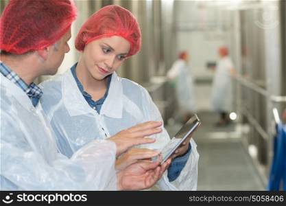factory workers in workshop using digital tablet