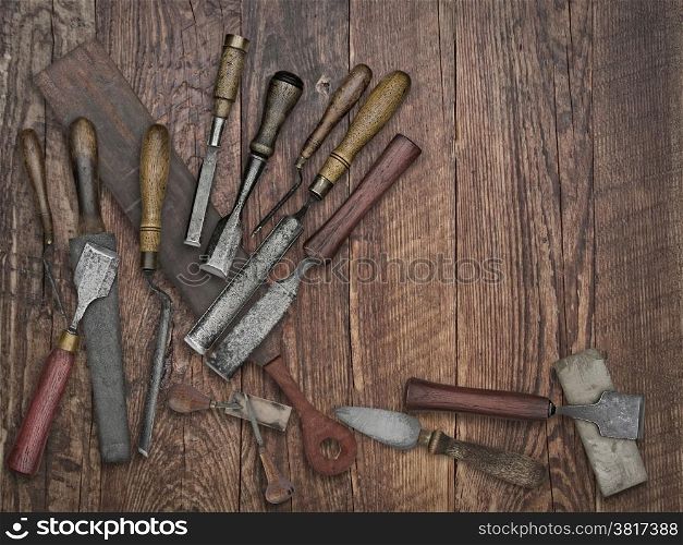 faded colors of a set of vintage chisels and sharpening stones, strop over wooden bench, space for your text
