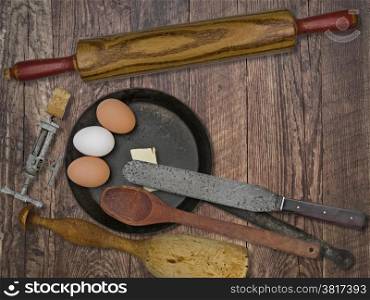 faded colors of a vintage utensils set, skillet, eggs,butter, space for your text