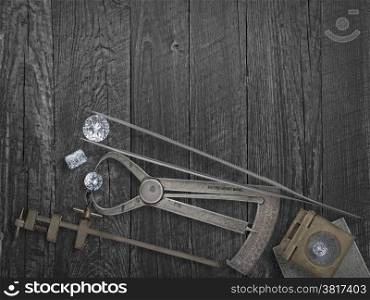faded colors vintage jewelers tools and diamonds over wooden bench, space for text