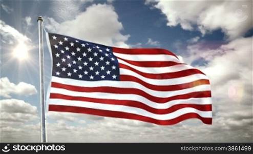 Fahne der USA weht im Wind. Darnber vorbeiziehende Wolken am Himmel bei strahlender Sonne.