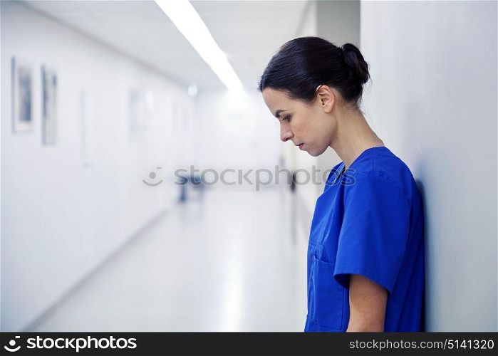 fail, people, health care and medicine concept - sad female nurse at hospital corridor. sad female nurse at hospital corridor