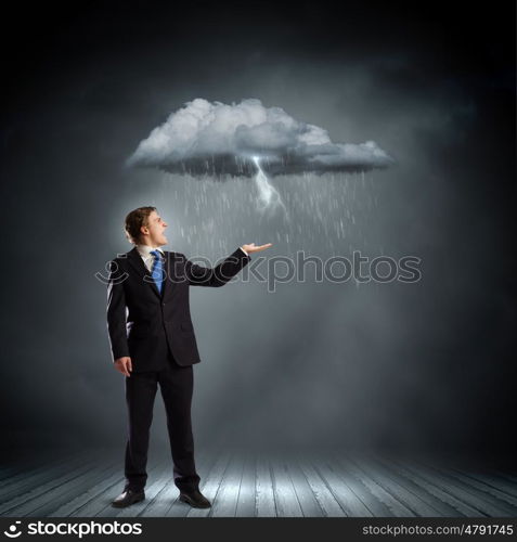 Failure in business. Young businessman under raining sky. Failure concept