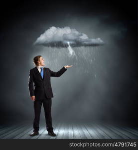 Failure in business. Young businessman under raining sky. Failure concept