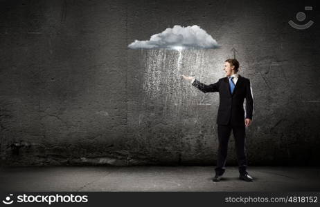 Failure in business. Young businessman under raining sky. Failure concept