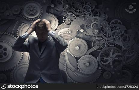 Failure in business. Young troubled businessman holding hands on head
