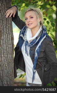 fair-haired woman under tree