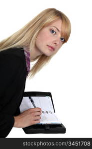 Fair-haired woman writing on a diary