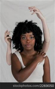 fair hands african young woman looking camera against grey backdrop