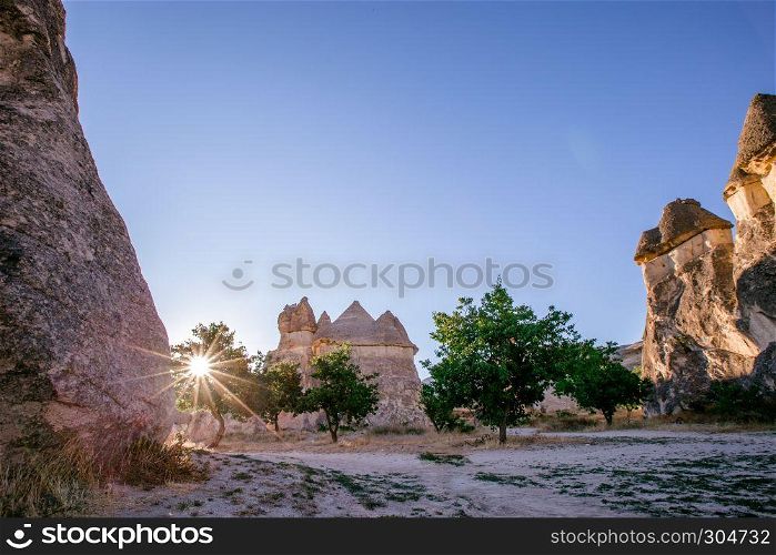 Fairy tale chimneys in Cappadocia, tourist attraction places to fly with hot air balloons. Goreme, Cappadocia, Turkey. Fairy tale chimneys in Cappadocia on the background of blue sky in Turkey.The great tourist attraction of Cappadocia one of the best places to fly with hot air balloons. Goreme, Cappadocia, Turkey
