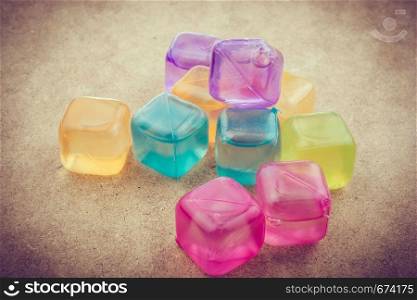 Fake colorful ice cubes on a brown background