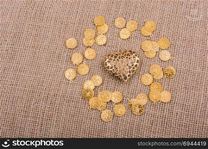 Fake gold coins around gold color heart