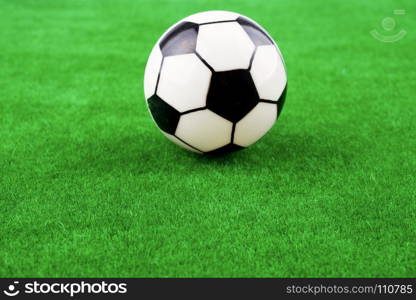 Fake soccer ball on a fake green grass field