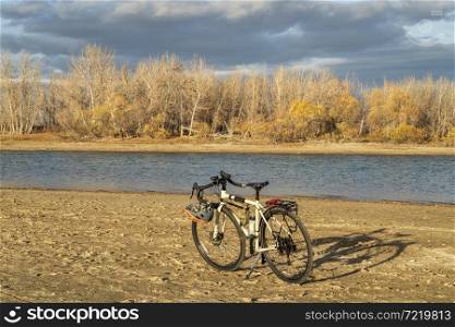 fall biking, touring or commuting - bicycle on a lake beach, Boyd Lake State Park in northern Colorado, November scenery