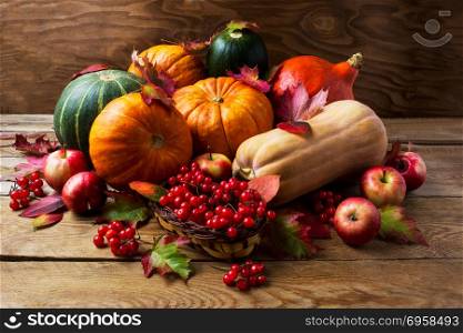 Fall concept with pumpkins, apples and berries. Fall concept with pumpkins, apples and berries. Thanksgiving background with seasonal vegetables and fruits. Abundant harvest background.