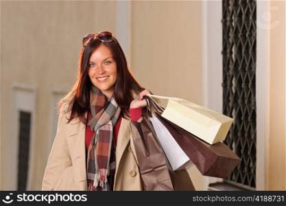 Fall elegant woman carrying shopping bags posing city street sunset