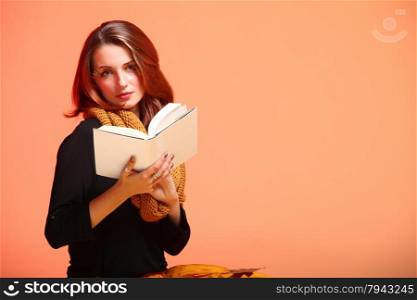 Fall. Fashion woman in autumn color student girl in full length with book long false orange eye-lashes