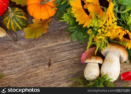 Fall frame with mushrooms, leaves and pumkins on wooden table
