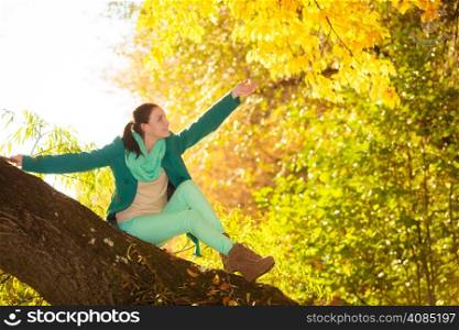 Fall lifestyle concept, harmony freedom. young woman girl relaxing in autumnal park. Golden colorful leaves background