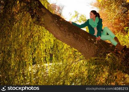 Fall lifestyle concept, harmony freedom. young woman girl relaxing in autumnal park. Golden colorful leaves background