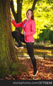 Fall season. Full length of happy girl young woman in pink in autumnal park forest. Outdoor.