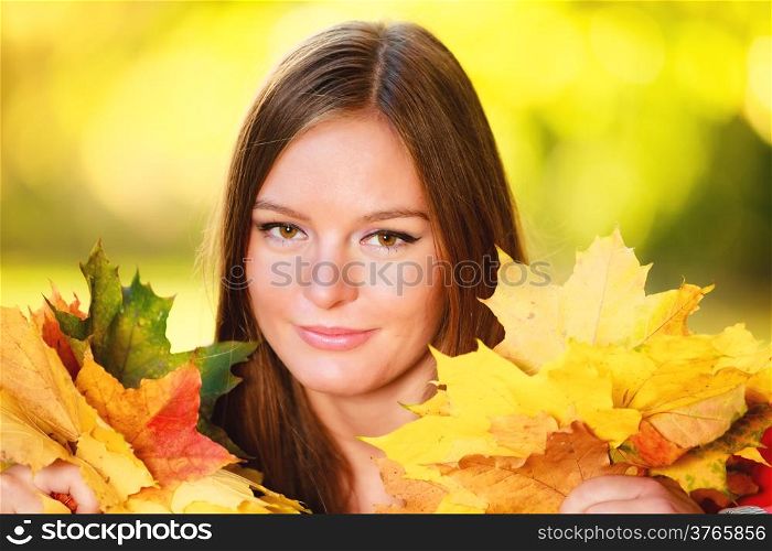 Fall season. Portrait of happy girl young woman holding colorful leaves in autumnal park forest. Outdoor.