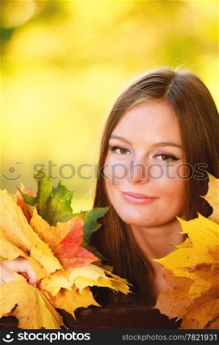 Fall season. Portrait of happy girl young woman holding colorful leaves in autumnal park forest. Outdoor.