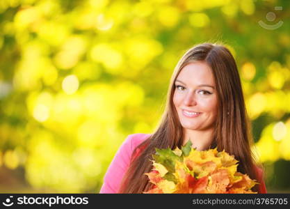 Fall season. Portrait of happy girl young woman with bunch of colorful leaves in autumnal park forest. Outdoor.