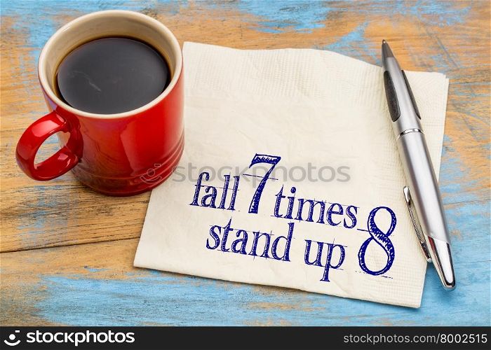 Fall seven times, stand up eight. Japanese proverb on napkin with a cup of coffee. Determination concept.