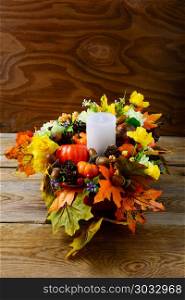 Fall table centerpiece with candle and silk maple leaves, vertical. Thanksgiving greeting with fall decor. Fall centerpiece. Thanksgiving background. . Fall table centerpiece with candle and silk maple leaves, vertic