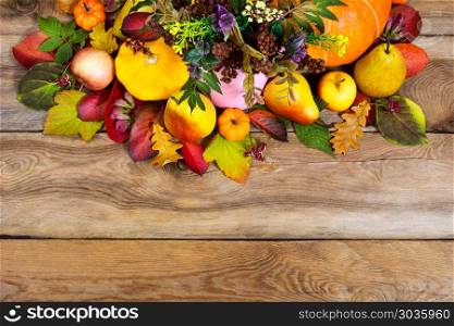 Fall vegetables and fruits on wooden table. Ripe pears, apples, pumpkins, red, green, yellow fall leaves on the wooden background, copy space
