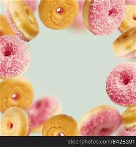 Falling or flying pink glazed doughnuts with sprinkles in motion at pastel blue background , frame