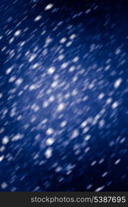 Falling snow background - snowflakes over night dark sky