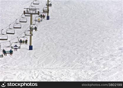 Fallscreek Aipex. Snow resort with skiers sitting on a chairlift with snow background