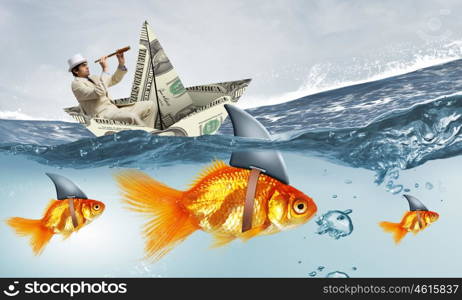 False risk for your business. Concept of fake threat when businessman float in dollar ship and sharks in water appear to be goldfish