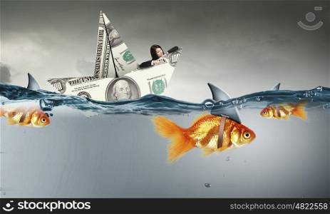 False risk for your business. Concept of fake threat when businesswoman float in dollar ship and sharks in water appear to be goldfish