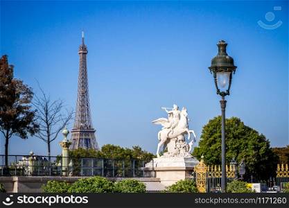 Fame straddling Pegasus statue and Eiffel Tower view from the Tuileries Garden, Paris, France. Marble statue and Eiffel Tower view from the Tuileries Garden, Paris