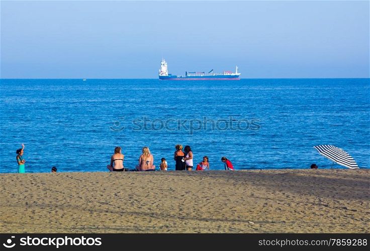 Families enjoy the blue sea on the beach Malagueta in Malaga Spain