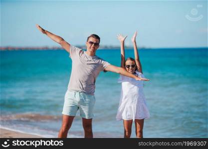 Familly of dad and daughter have fun together on the beach. Little girl and happy dad having fun during beach vacation