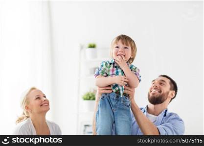 family, adoption and people concept - happy child with parents at home. happy family at home