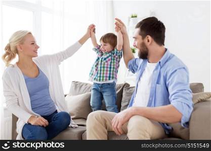 family, adoption and people concept - happy child with parents having fun at home. happy family having fun at home