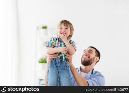 family, adoption and people concept - happy father and son having fun at home. happy family father and son