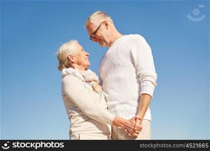 family, age and people concept - happy senior couple holding hands talking outdoors