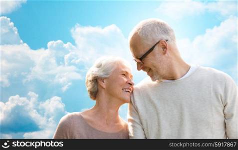 family, age, love, relations and people concept - happy senior couple over blue sky and clouds background