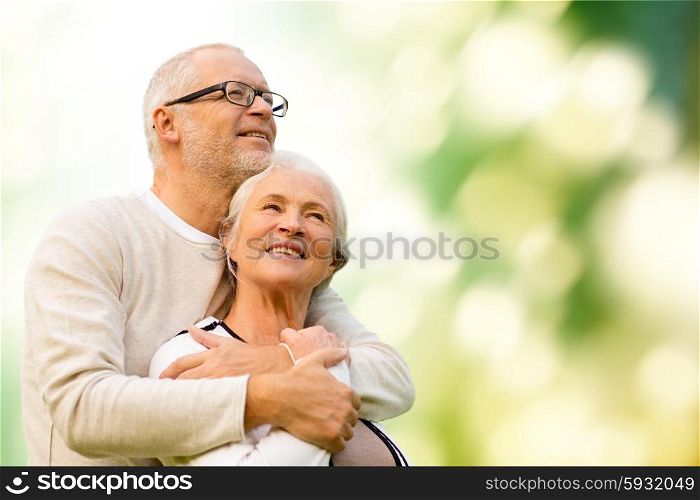 family, age, love, relations and people concept - happy senior couple over green natural background