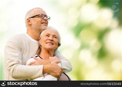 family, age, love, relations and people concept - happy senior couple over green natural background